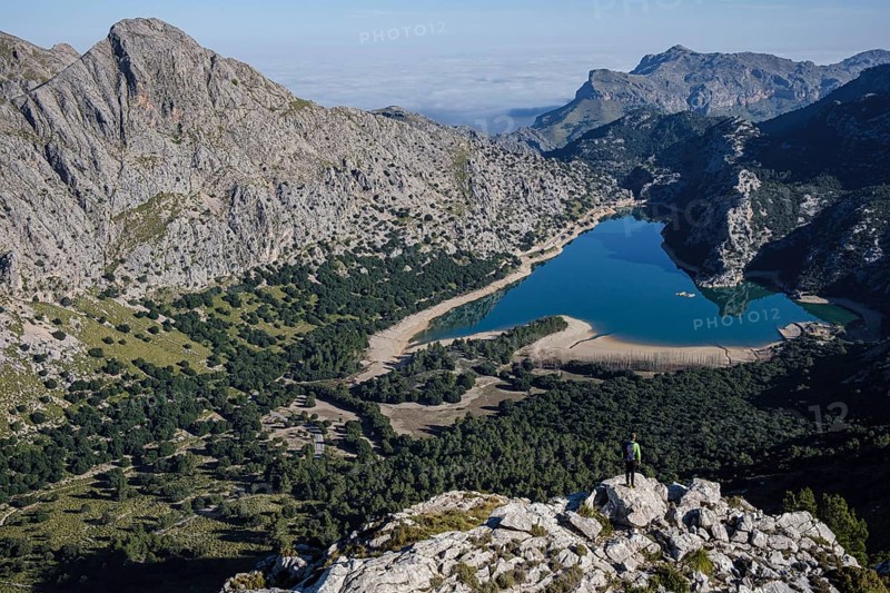 Hiker watching Gorg Blau reservoir, Escorca, Mallorca, Balearic Islands, Spain