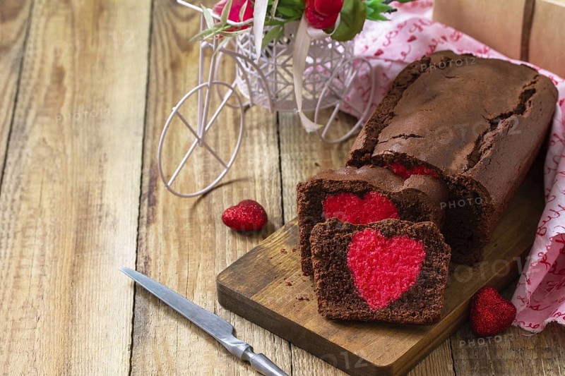 St. Valentine's Day, Birthday or Mother's Day dessert, homemade festive food. Homemade sweet chocolate brownie cake with red heart on a wooden rustic tabletop. Copy space