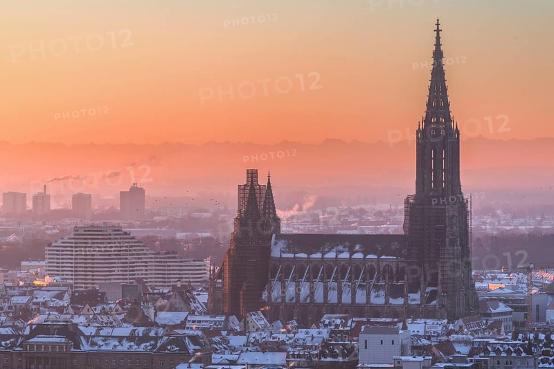 City Ulm in winter with fresh snow and fog. Mountains Alps in background with Minster