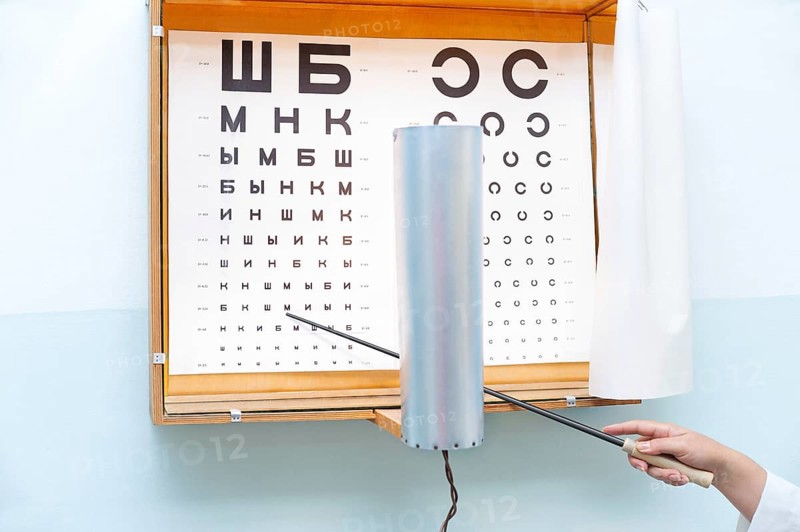 A Russian eye chart at an oculist and a hand with a pointer