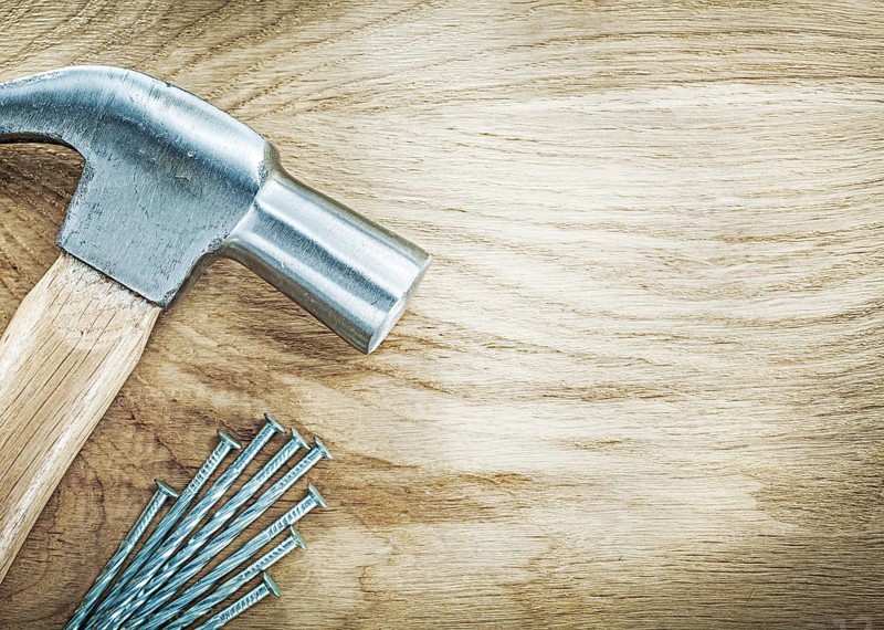 Claw hammer stainless nails on wooden board building concept