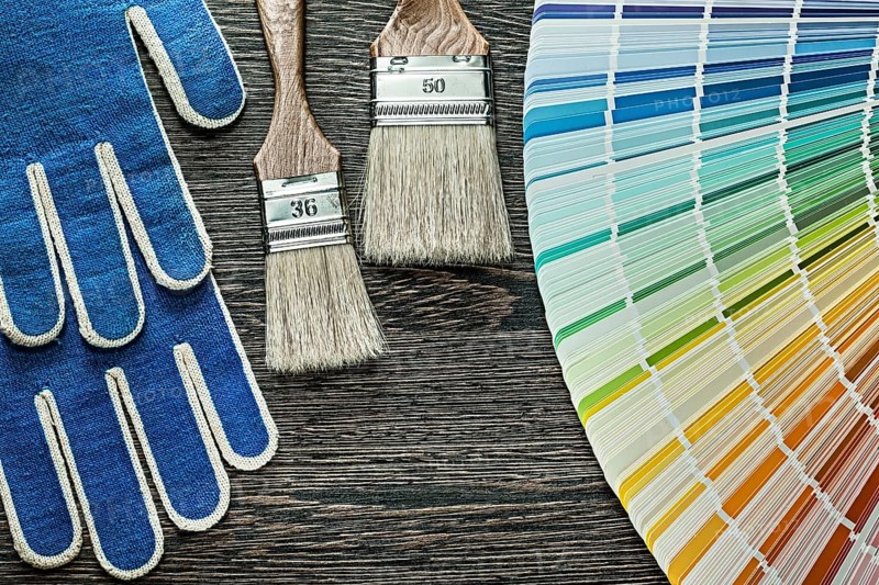 Safety gloves paint brushes pantone fan on wooden board