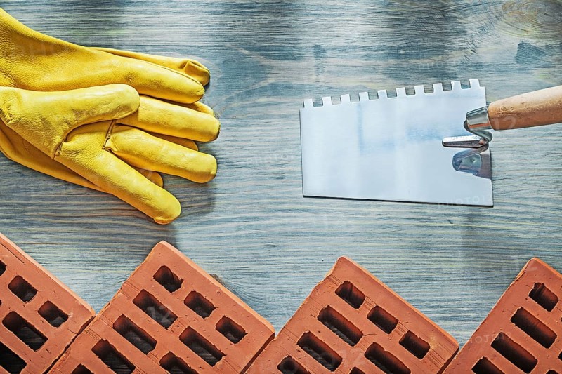 Red bricks safety gloves bricklaying trowel building concept