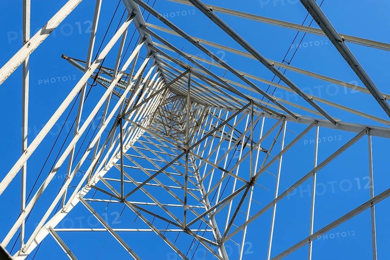 High Voltage Electricity Grid Pylon seen from below and blue sky
