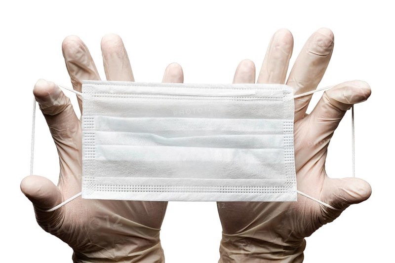 Doctor holding surgery medical face mask in hands in gloves isolated on white background. Medicinal concept protective clothing, equipment during corona virus, global pandemic, hygiene and health care