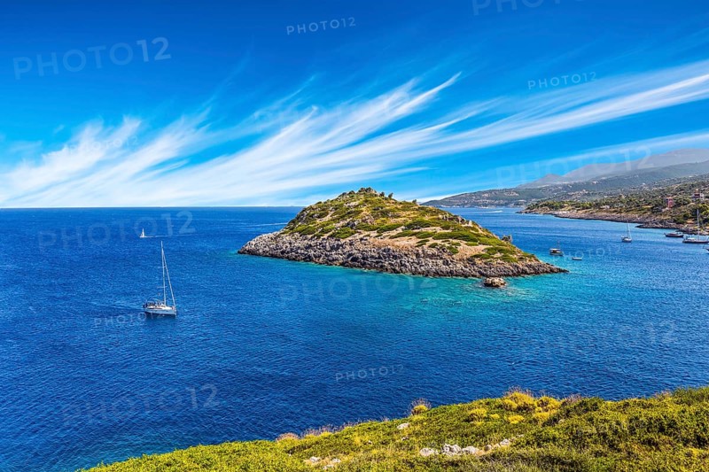Holiday in Greece, island of Zakynthos. Bright blue sea water reflects coastal cliffs. Snow-white yacht sails along the rocky shores of the island. The concept of marine, active and resort recreation