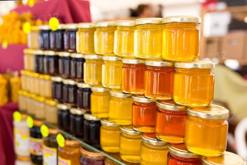 Different small jars of honey - herbal honey, lavender honey, linden honey and mixed honey