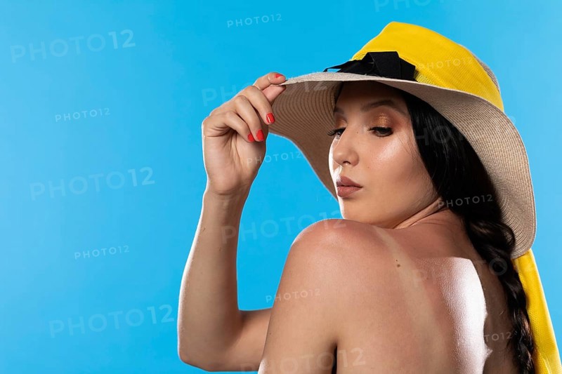 A teenager in a big beach hat holds a hand on a tanned shoulder