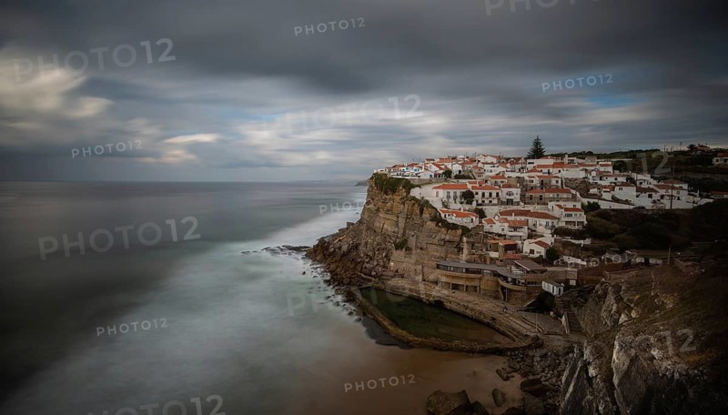 Picturesque village of Azenhas do mar at the top of a rocky hill on the Atlantic Ocean. Long exposure photography
