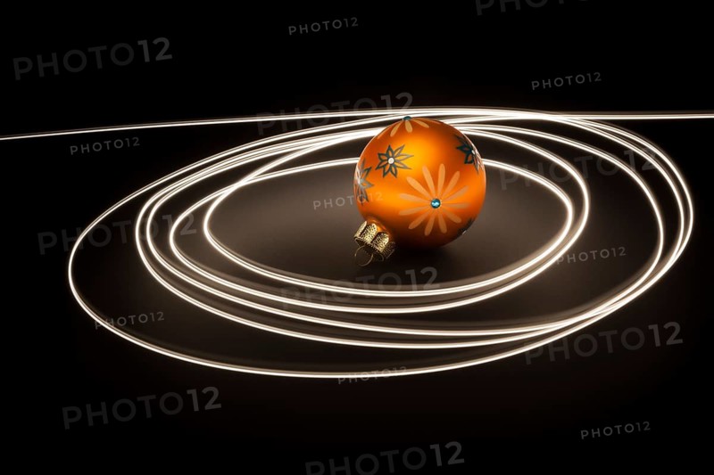 An image of an orange christmas ball with light streaks