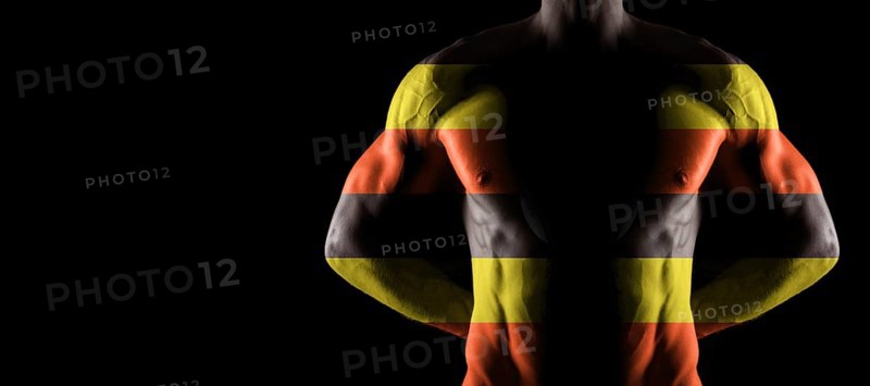 Uganda flag on muscled male torso with abs, black background