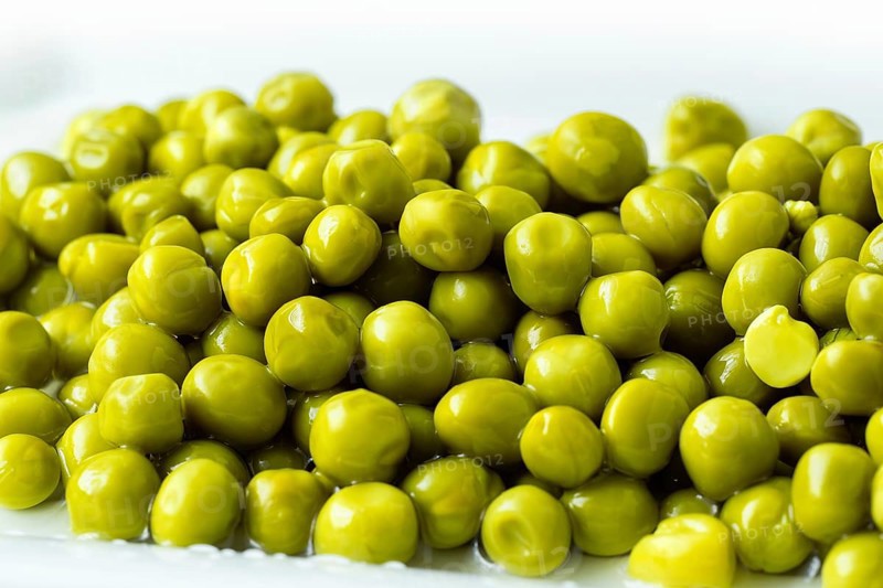 White bowl with canned green peas. Fermented food