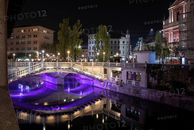 Famous three bridges at the Preseren square in the center of Ljubljana colorfully illuminated at night, Slovenia