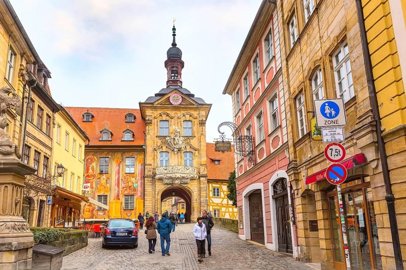 Bamberg, Germany, February 19, 2017: Icon of Bamberg Obere bridge or brucke and Altes Rathaus town hall city center, people