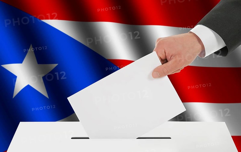 The Puerto Rico flag and the hand with the bulletin about the ballot box