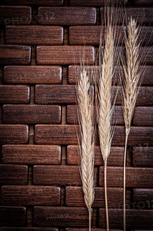 Golden wheat and rye ears on wooden matting