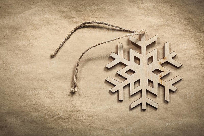 Vintage wooden snowflake string on paper background holidays concept