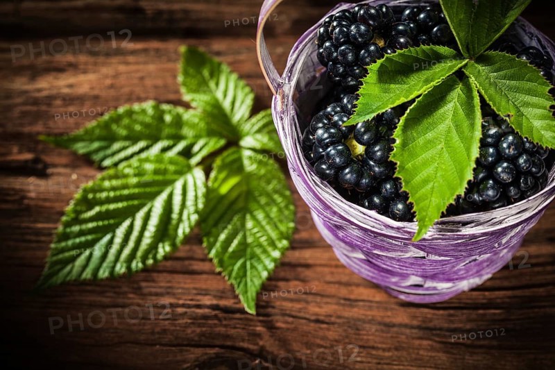 Sweet blackberries in basket leaf on vintage wooden board