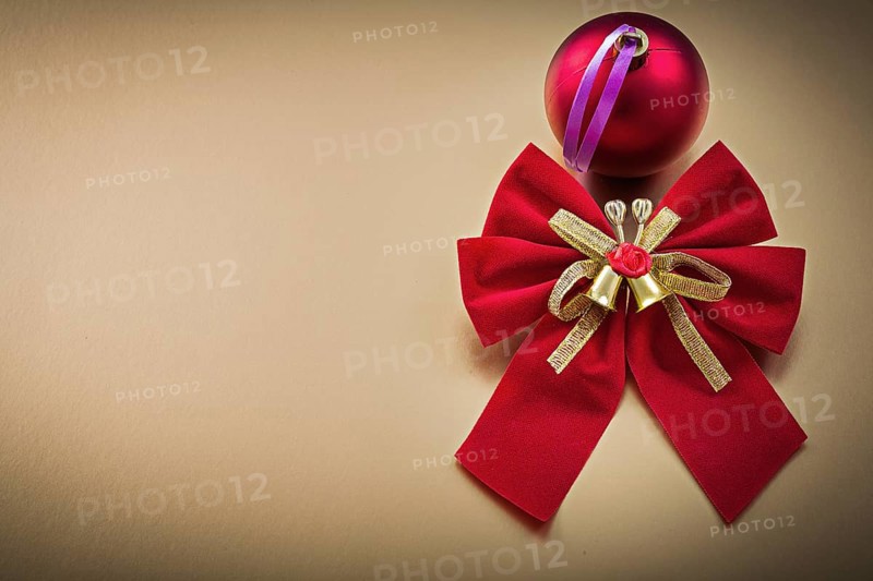 Red bow ball on golden background holidays concept