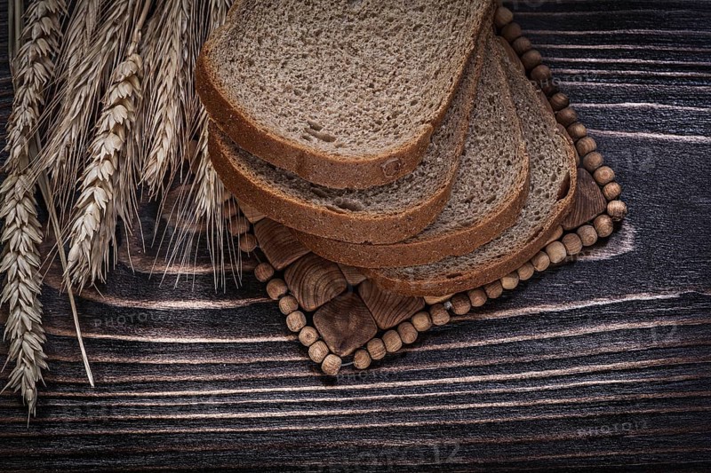 Golden rye wheat ears sliced loaf of bread wicker mat food and drink concept