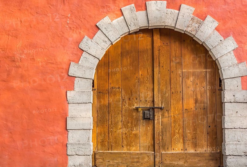 Medieval building entrance with an arched double door, made from hard wood