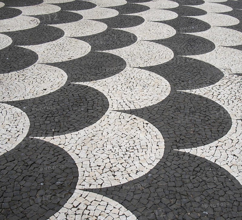 Traditional portugal black and white fish scale pattern tiled cobblestone sidewalk in funchal madeira