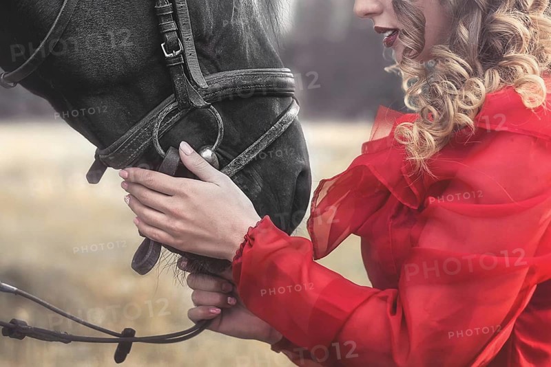 Love for animals. young Woman with no face dressed in an elegant vintage dress, gently cuddling a horse, stroking his head