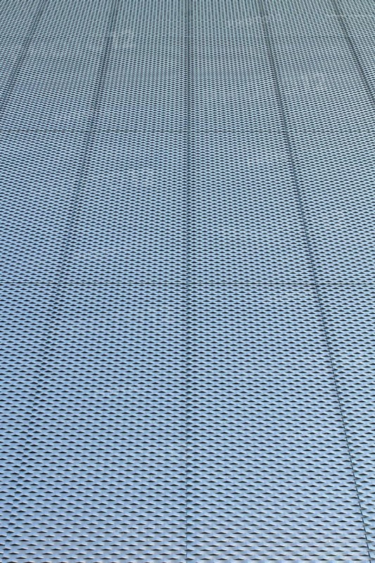 Closeup of metal mesh on concrete wall background texture