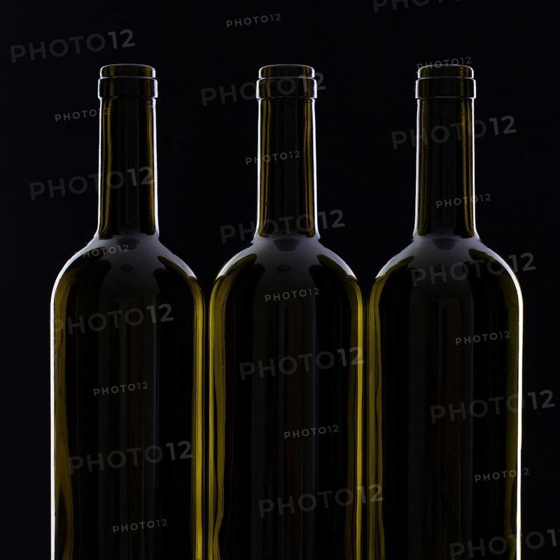Three different bottles of wine on the black glass
