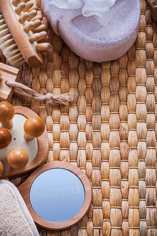 Vanity mirror wooden massagers nail brush and soft bath sponges on wicker background sauna concept