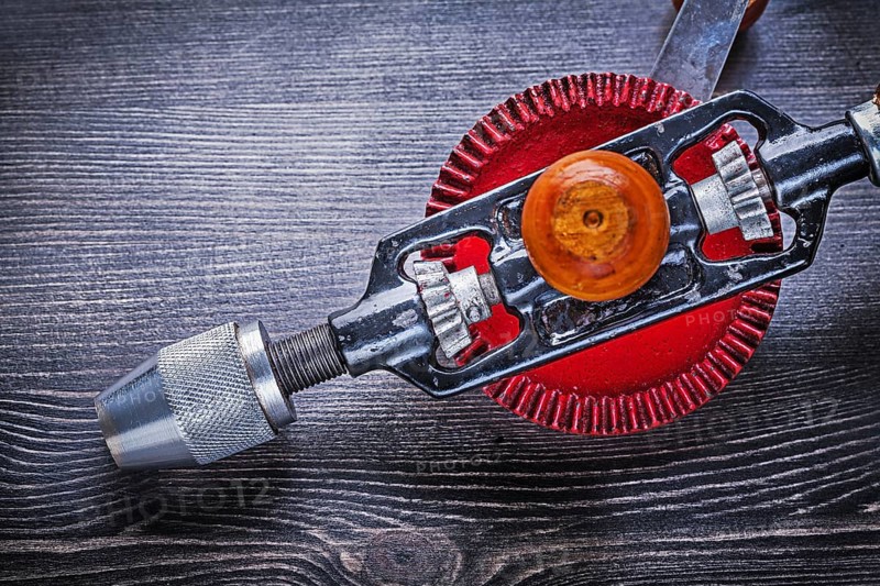 Vintage hand drill on wooden board