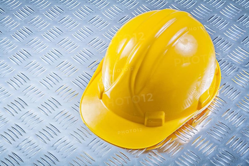 Safety building helmet on grooved metal plate construction concept