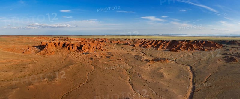 Aerial panorama view of the Bayanzag flaming cliffs at sunset in Mongolia, found in the Gobi Desert