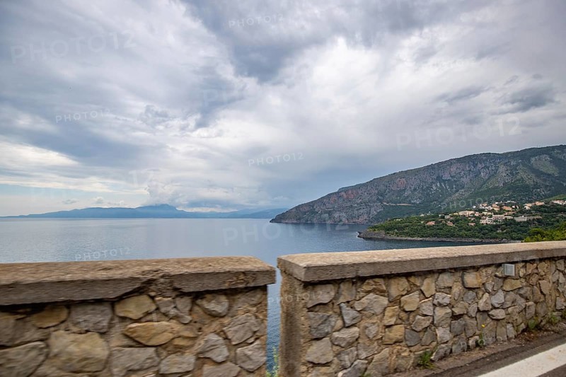 Coastal landscape shot. View from a road leading along the sea and through a breathtaking green Mediterranean landscape. Coast near Salerno, Italy