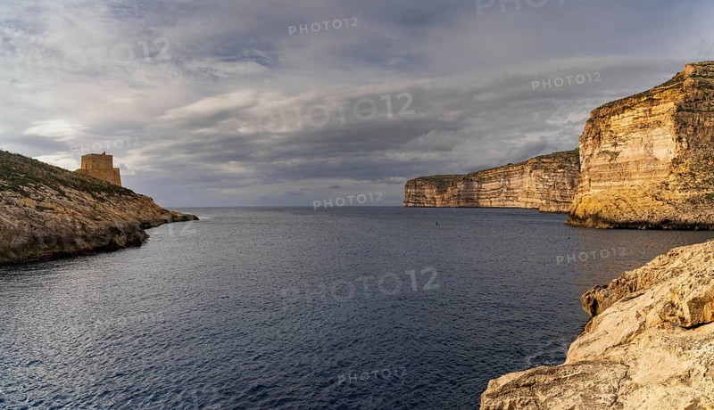 A view of the Xlendi Bay watchtower and cliffs on the coast of Gozo Island in Malta