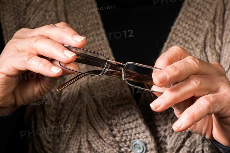 Old women hands hold glasses