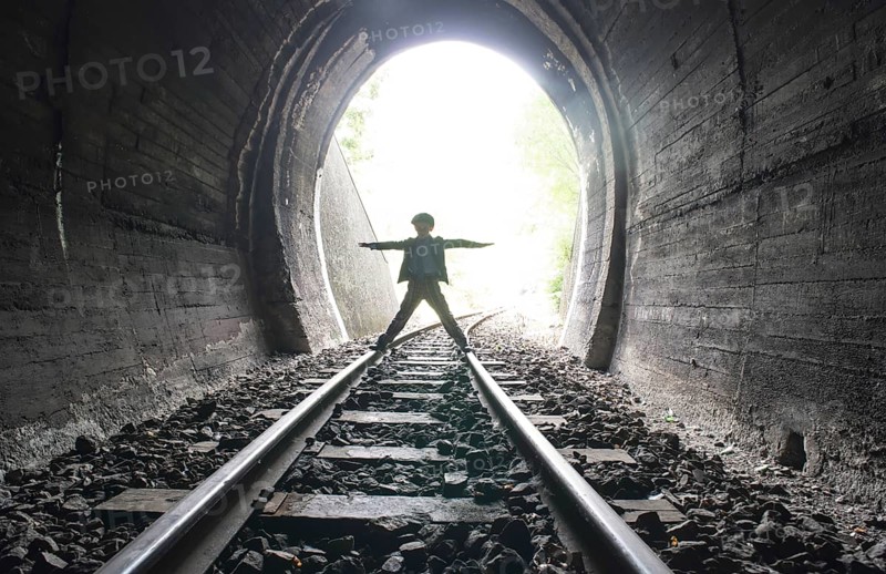 Child walking in railway tunnel. Vintage clothes