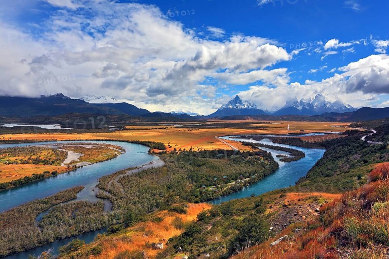 Glen Serrano. Meandering river bed of yellow autumn coast. Valley surrounded by snow-capped mountains