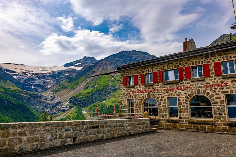 Terrace and Restaurant View over Beautiful Mountain Alp Grüm with Glacier and Alpine Lake Palü in a Cloudy Summer Day in Poschiavo, Bernina, Grisons, Switzerland