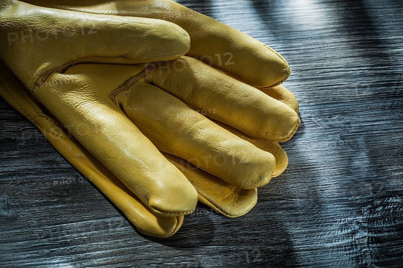 Leather safety gloves on vintage wooden board