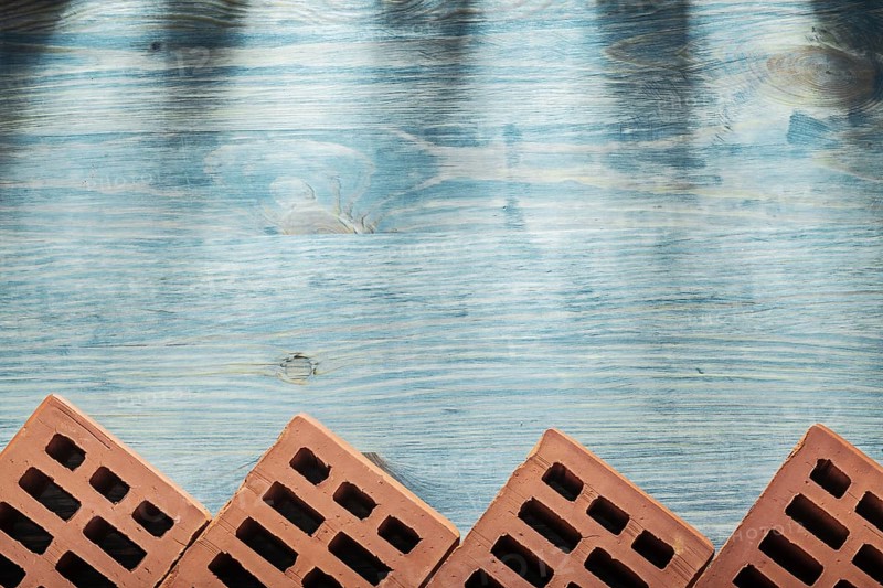 Red bricks on wooden board horizontal version building concept