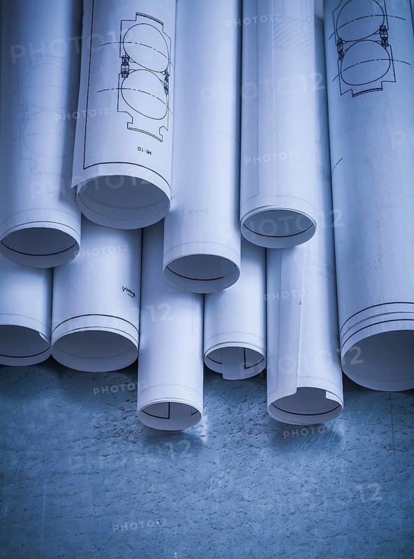Heap of engineering drawings on scratched metallic background building and architecture concept