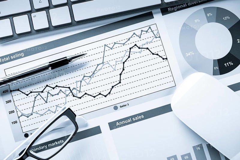 Business workplace with keyboard mouse and papers with graphs and diagrams