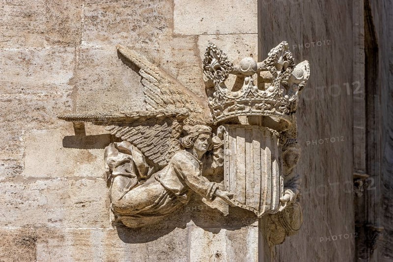 Stone sculpture of two angels with the coat of arms and crown of Valencia on the corner of a stone building in the centre of the old town, Valencia, Autonomous Community of Valencia, Province of Valencia, Spain