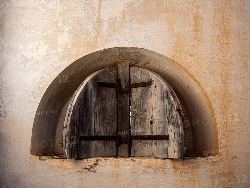 A picture of a rusty window of an abandoned fortress
