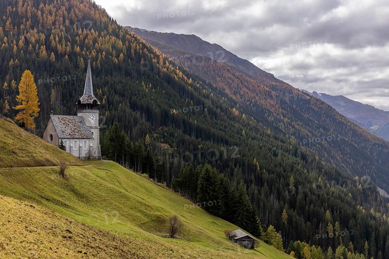 Church of St. Peter with golden larch in autumn, Monstein, Davos, Grisons, Switzerland