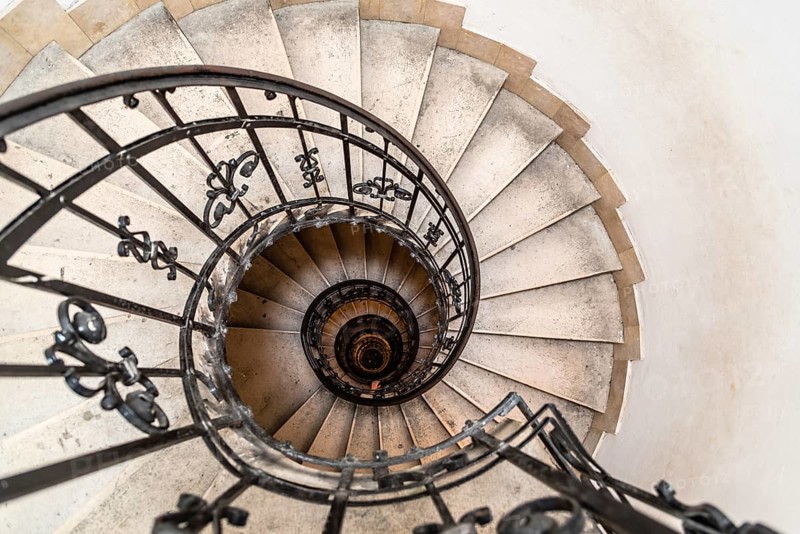 High angle view of spiral staircase with hand of man below