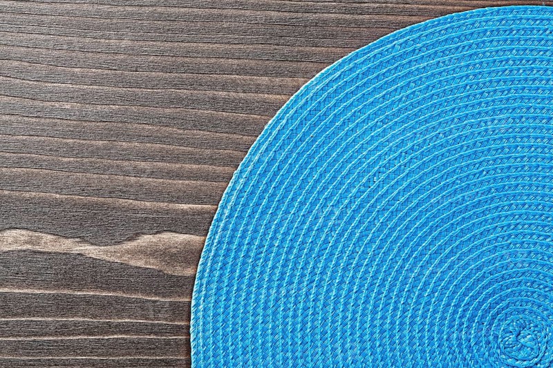 Blue wicker table matting on wooden board