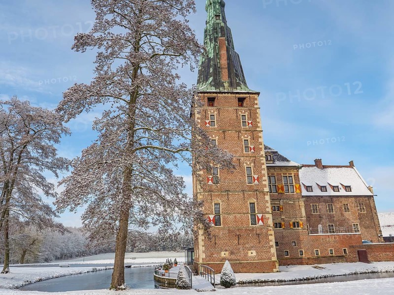 A castle with high towers, snow-covered trees and a clear sky in winter, raesfeld, münsterland, germany