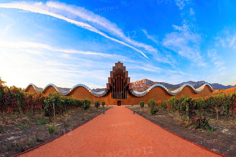 The magnificent modern architecture of Bodegas Ysios. Bright flaming colors of the sunset. Journey to the warm Spanish autumn. Fantastic beauty